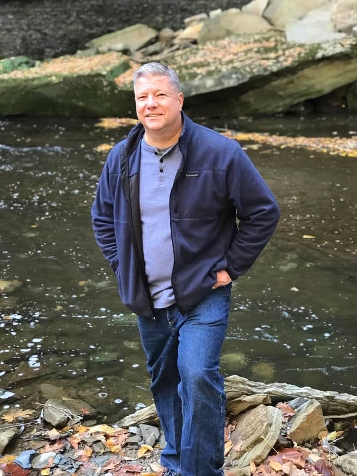 Eric Mansfield standing beside a wooded Northeast Ohio creek.